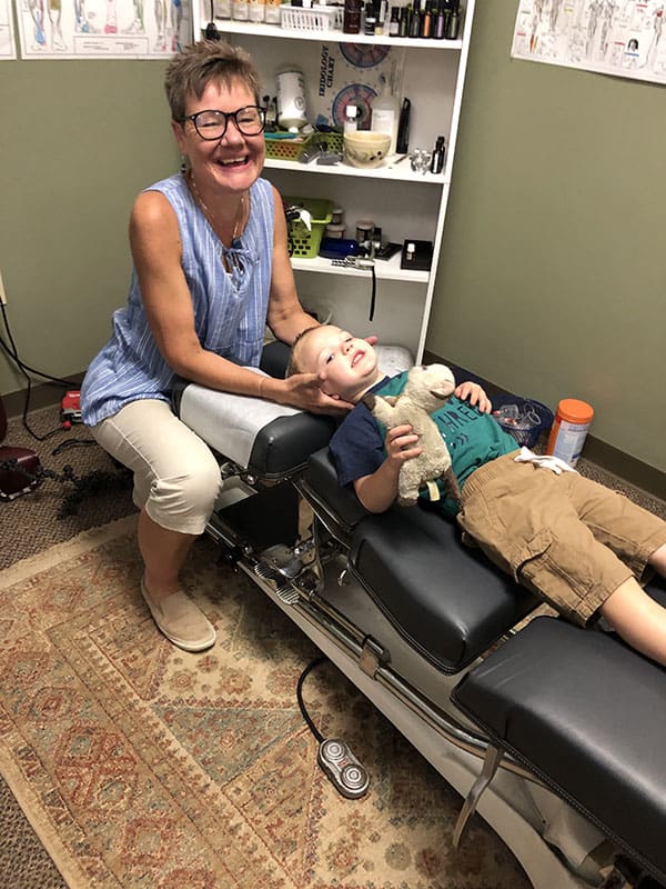Dr. Julie Holtz adjusting a boy's neck